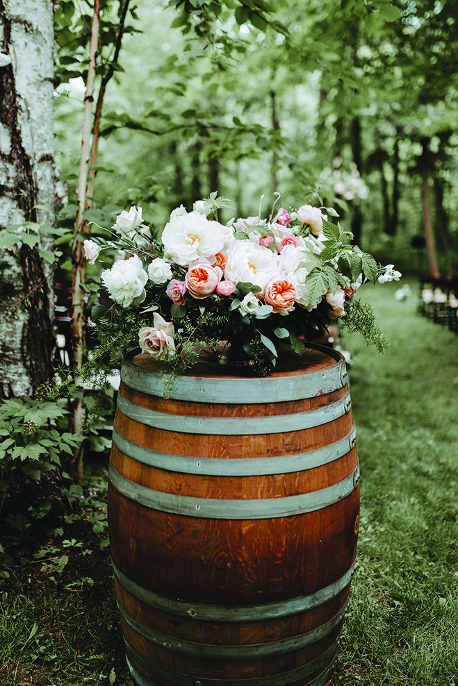 Flowers in a barrel at Kate and Lucas' wedding at Creekside Farm Weddings & Events