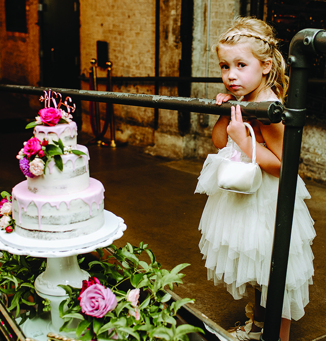 A young girl looks at Molly and Seth's wedding cake.