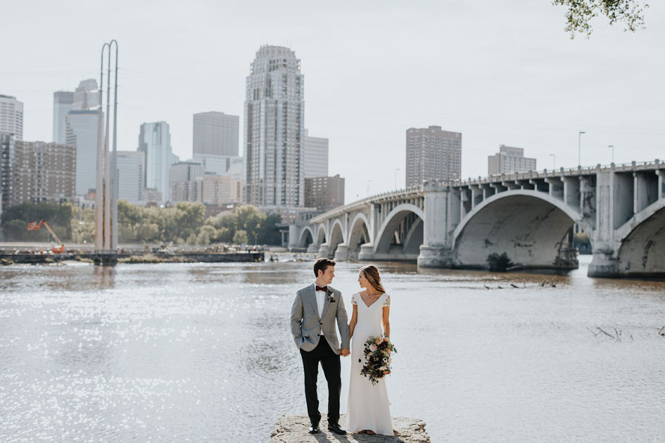 Kelsey and Grant stand before the Stone Arch Bridge