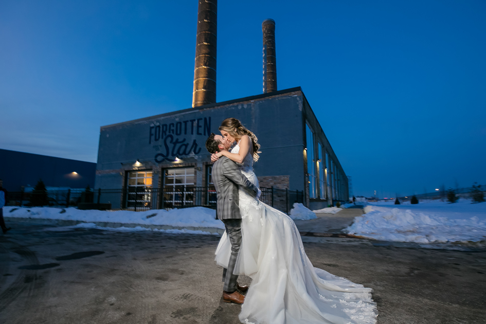 Newlyweds kissing outside of Northern Stacks wedding venue. 