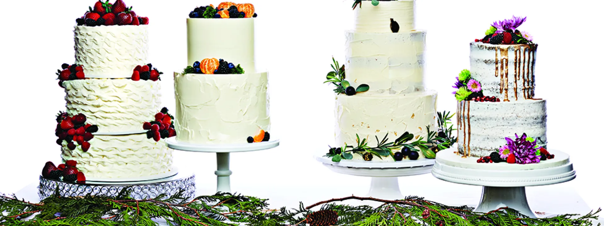Three tiered, buttercream wedding cakes with fruit.