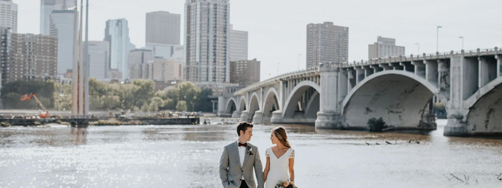 Kelsey and Grant stand before the Stone Arch Bridge