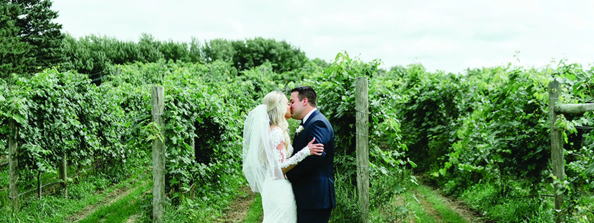 Tom and Chelsey kiss on their wedding day at Round Lake Vineyards & Winery