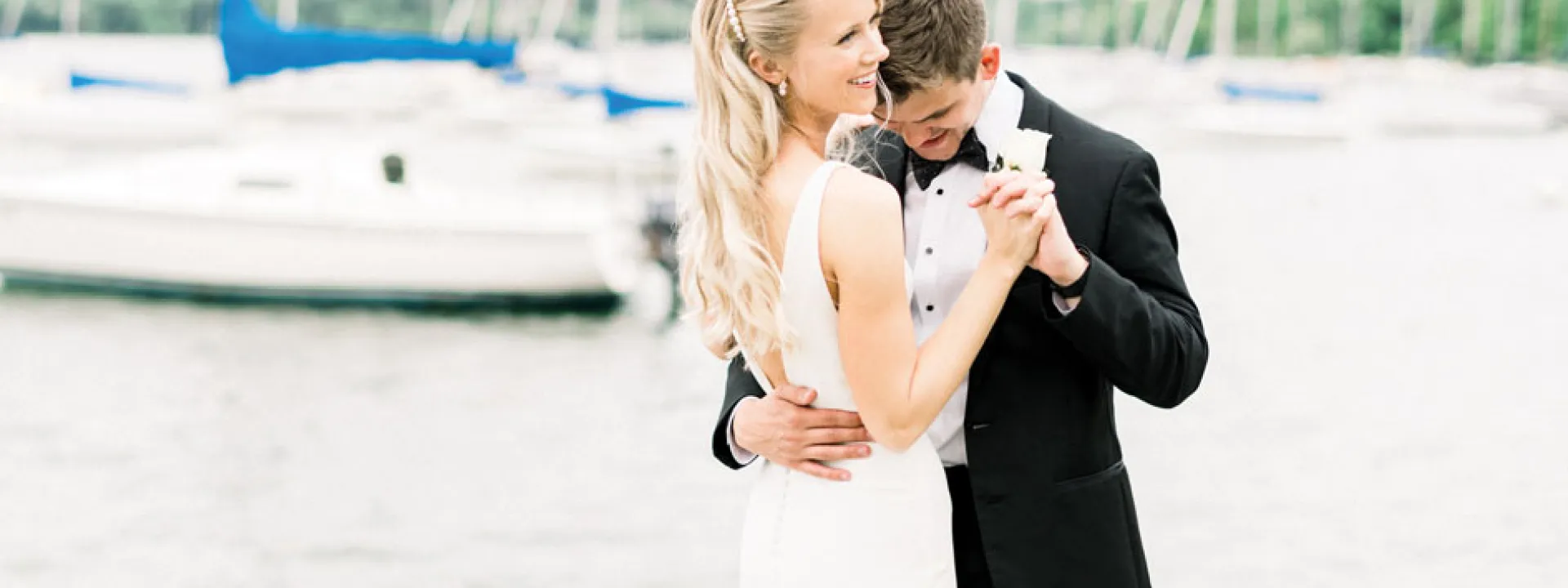 A bride and groom on a lake at their first dance.
