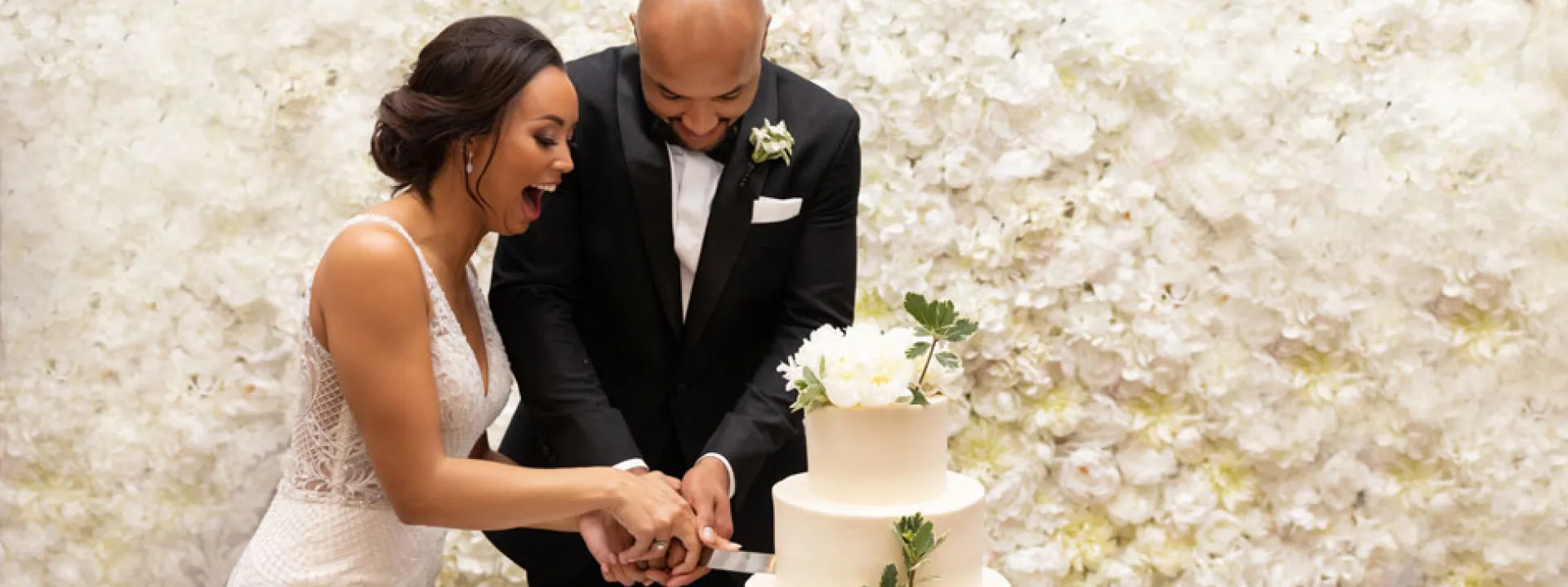 The bride cuts the cake with the groom (former Minnesota Vikings player Michael Floyd).