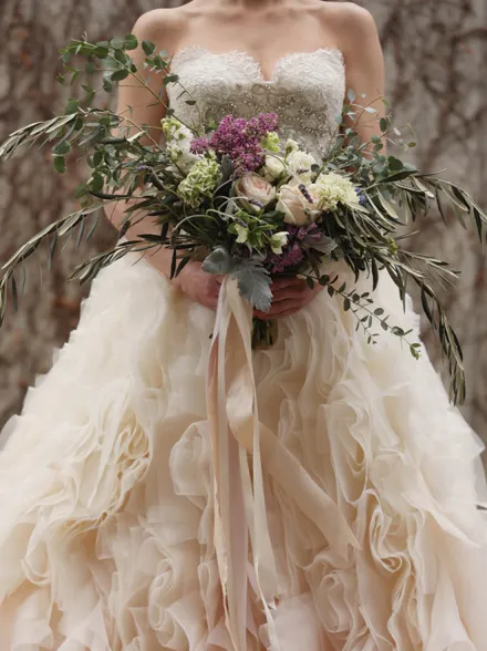 Ruffled wedding dress with large bouquet